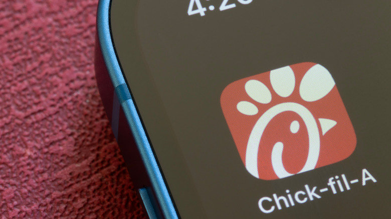 Phone screen displays the Chick-fil-A app icon.
