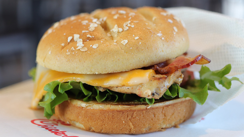A Chick-fil-A grilled chicken sandwich features lettuce, melted cheese, and bacon on bun.