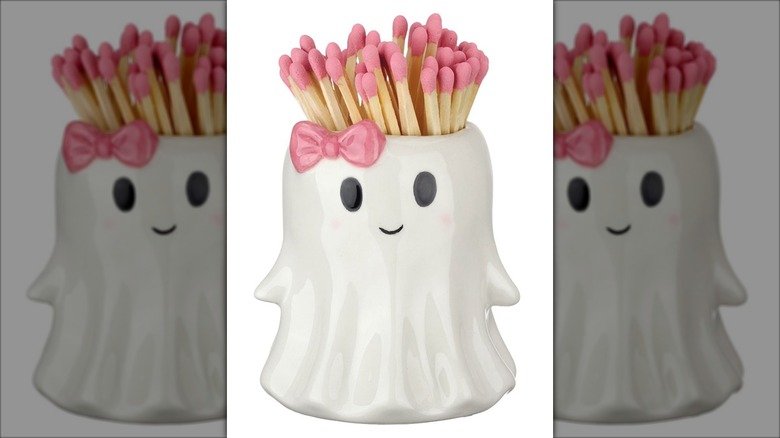 A matchstick holder shaped like a cute and friendly Halloween ghost with a pink bow.