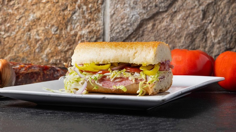 sandwich on plate with tomatoes in background