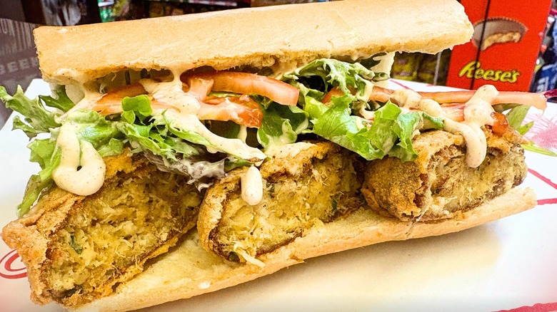 Fried crab cake po' boy with greens and remoulade sauce