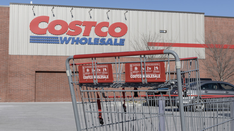 The exterior of a Costco warehouse and an empty shopping cart