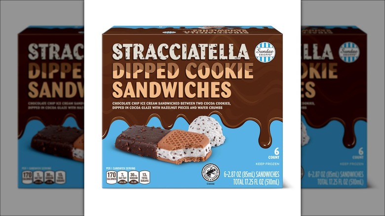 Box of stracciatella dipped cookie sandwiches against white background.