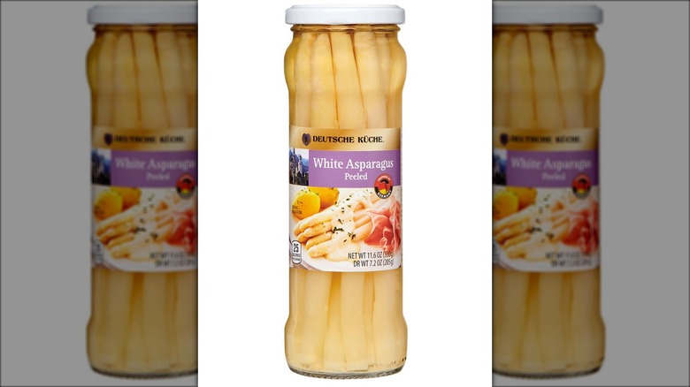 A tall, lean, transparent bottle of white asparagus labeled "White Asparagus."