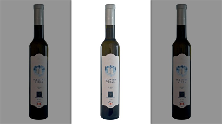A dark, tall, thin bottle decorated with a snowy landscape labeled "Icewine Vidal."