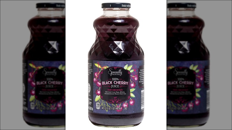 A glass bottle of dark purple liquid labeled "100% Black Cherry Juice."