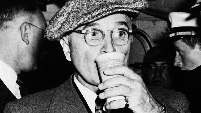 President Harry Truman taking a drink from a cup