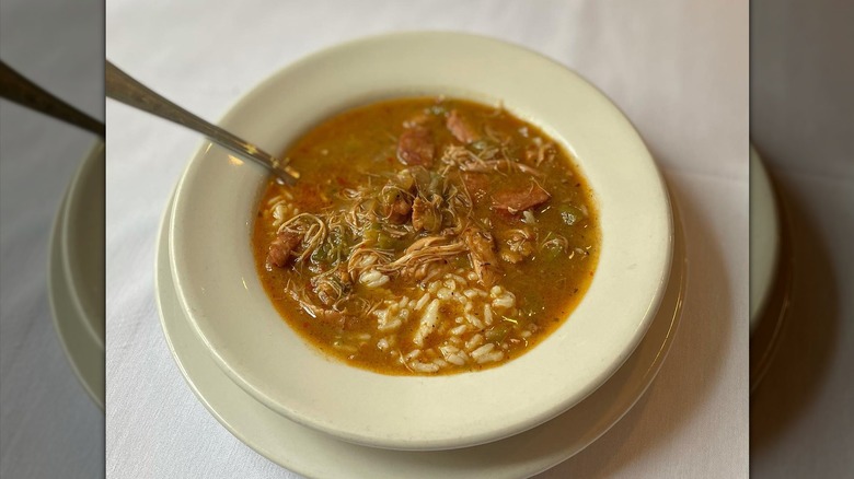 A simple bowl of gumbo with spoon on table with tablecloth