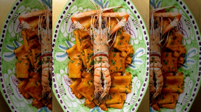 A pasta dish with vodka sauce and an entire langoustine on top of it