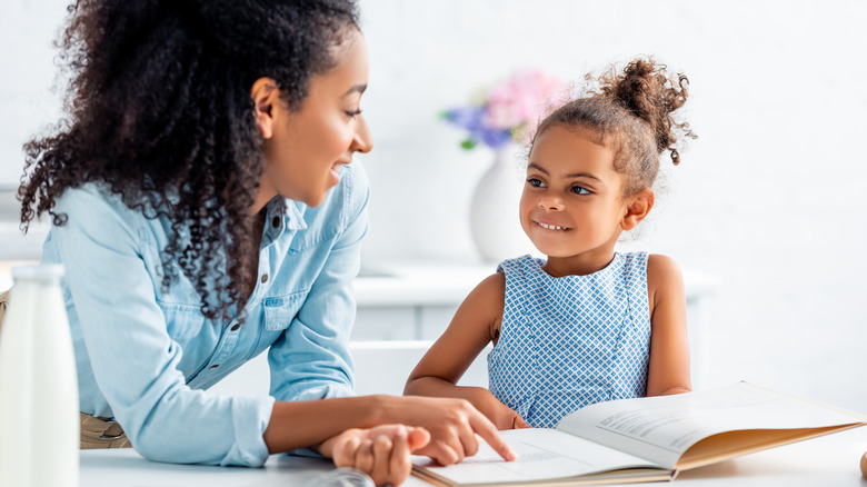 mother and daughter reading cookbook