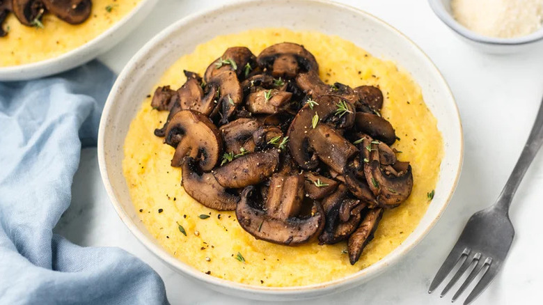 creamy polenta in a bowl with mushrooms on top