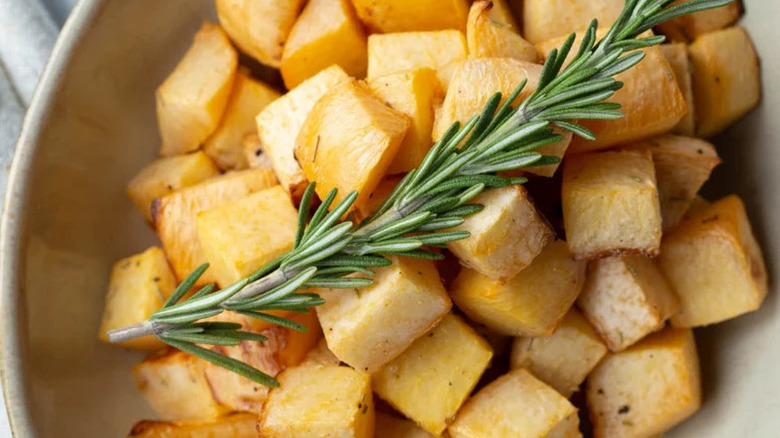 close up of roasted rutabaga with a sprig of rosemary