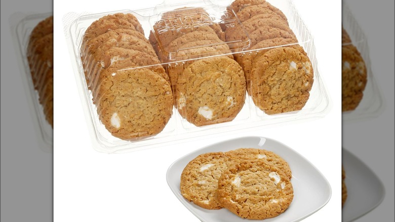 A pack of marshmallow-infused cookies behind three cookies on a plate.