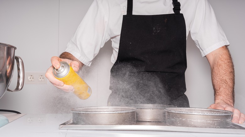 Man spraying cake pans