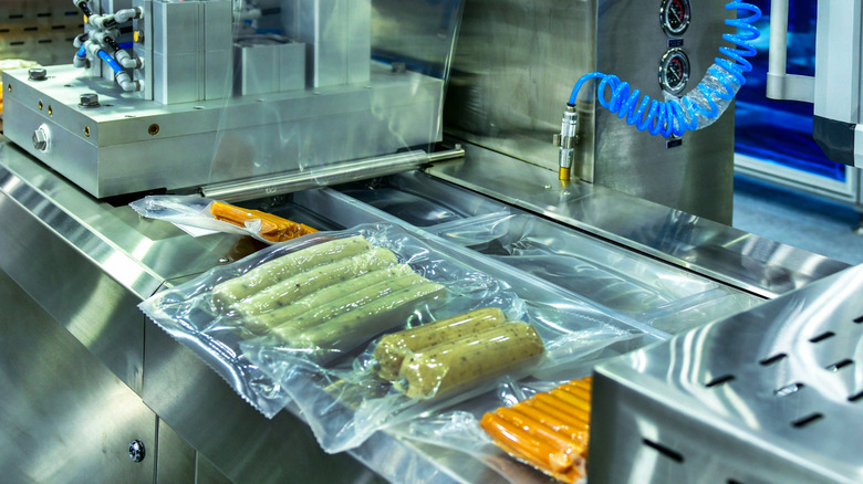 Packages of shrink-wrapped sausages in factory