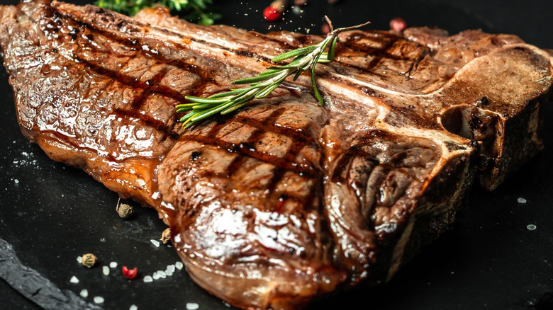 T-bone steak with seasoning and herbs