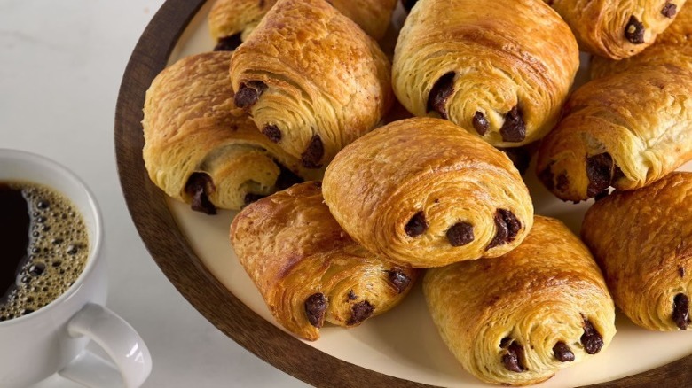 Member's Mark chocolate croissants displayed on platter with cup of coffee nearby