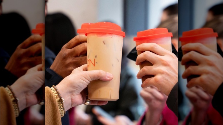 Three people holding iced coffee from Bon!