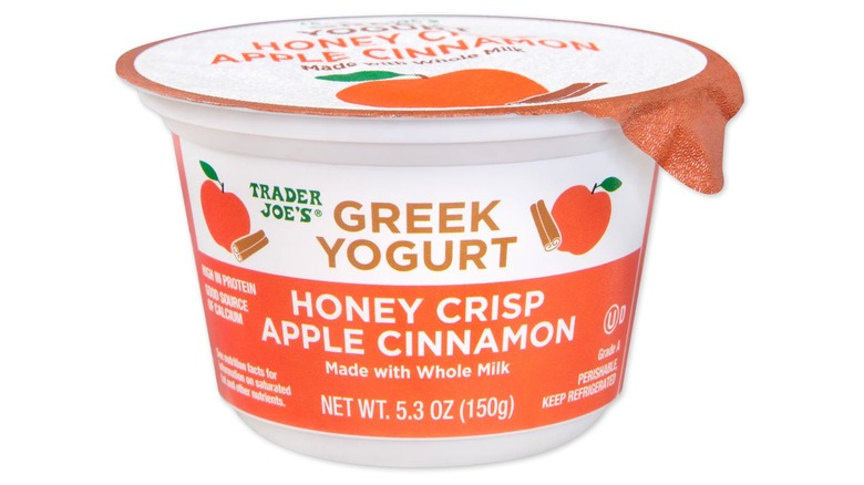 Container of honey crisp apple cinnamon-flavored Greek yogurt from Trader Joe's on white background.