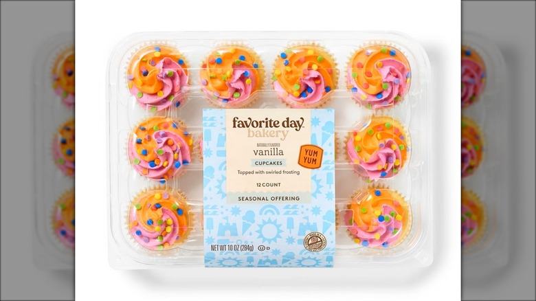 Cupcakes with multi-colored icing in plastic packaging.
