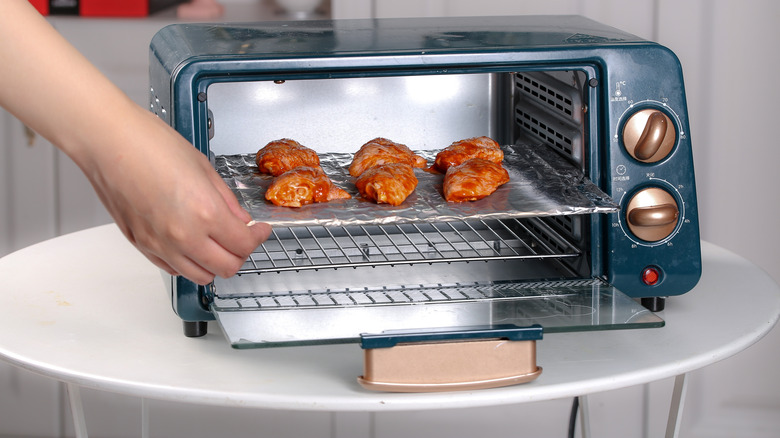 Chicken wings cooking in a toaster oven