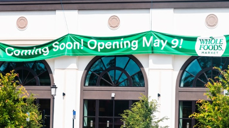 Banner outside a storefront that reads "Coming Soon! Opening May 9! Whole Foods Market"