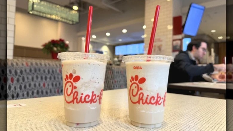 two chick-fil-a frosted soda drinks in takeout cups on table at restaurant