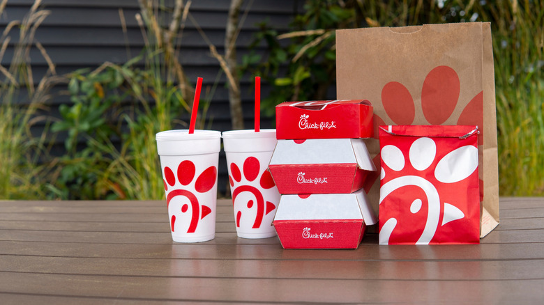 chick fil a takeout cups, boxes, and bags on a picnic table