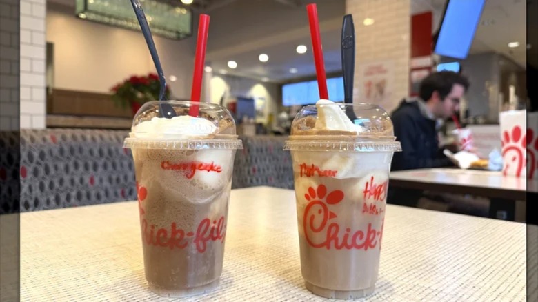 two chick-fil-a float drinks in takeout cups on table at restaurant