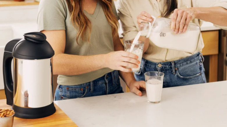 Pouring nutmilk made in the Almond Cow machine