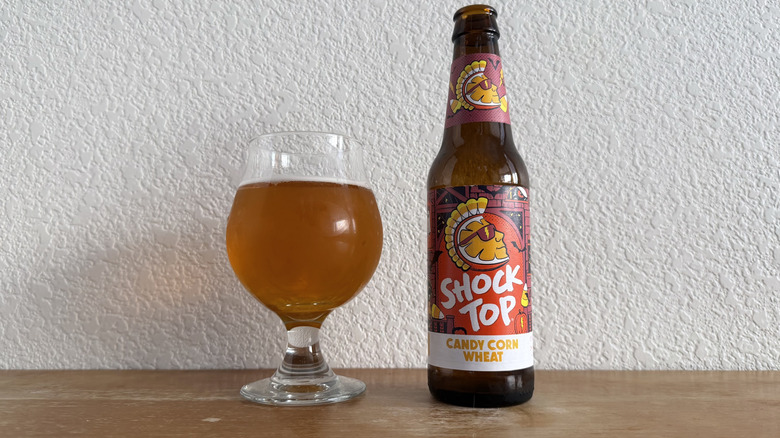 Shock Top Candy Corn Wheat Ale bottle beside a mostly full glass