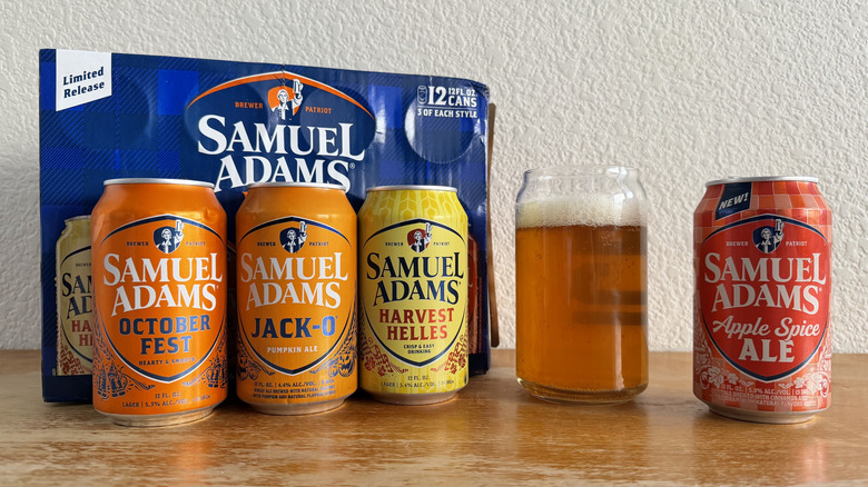 Apple Spice Ale can beside a mostly full glass as well as the box and other three cans from the variety pack