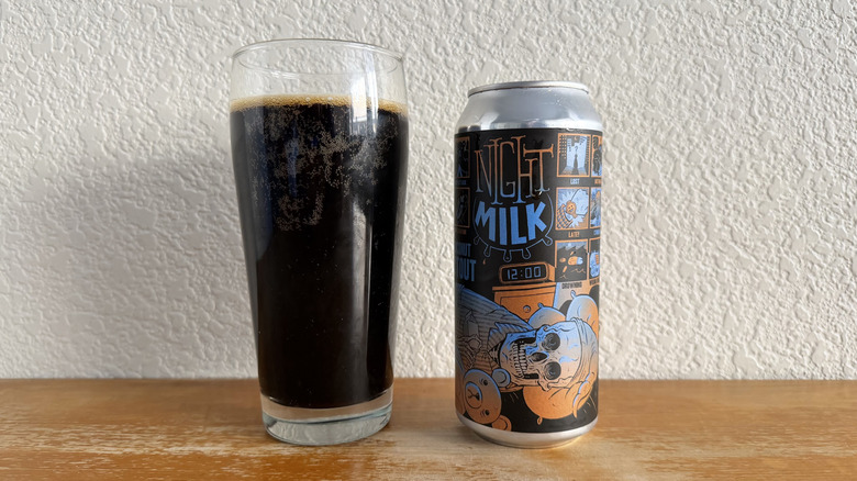 Abomination Coconut Night Milk can beside a mostly full glass