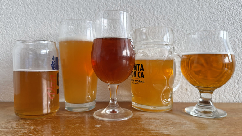 five beer glasses each a little over half-full