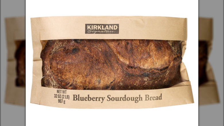 Bag with a fresh baked loaf of blueberry sourdough bread.