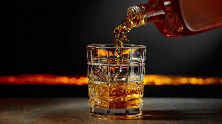 whiskey bottle pouring into glass