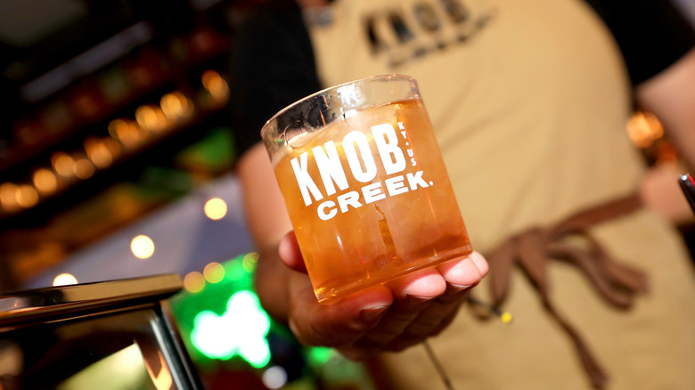 bartender holding Knob Creek whiskey glass