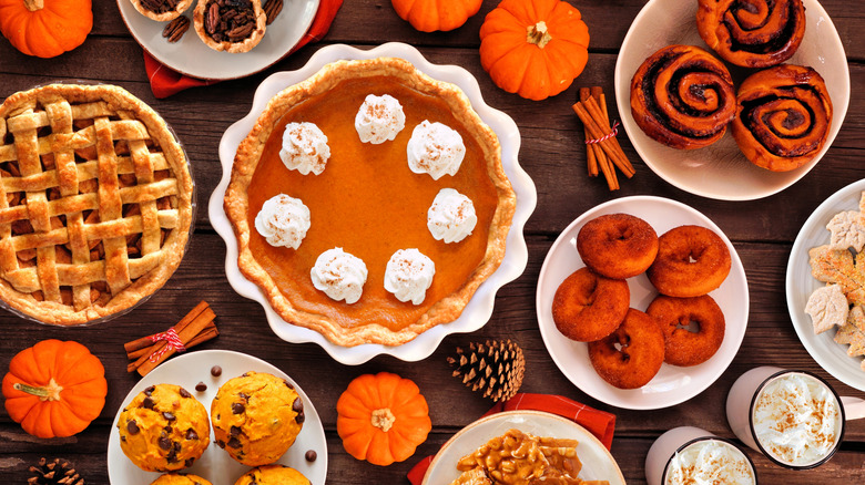 Assortment of fall desserts like pies, muffins, donuts, and cinnamon rolls.