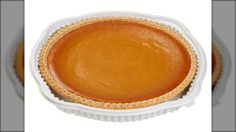 Large pumpkin pie in plastic tray.