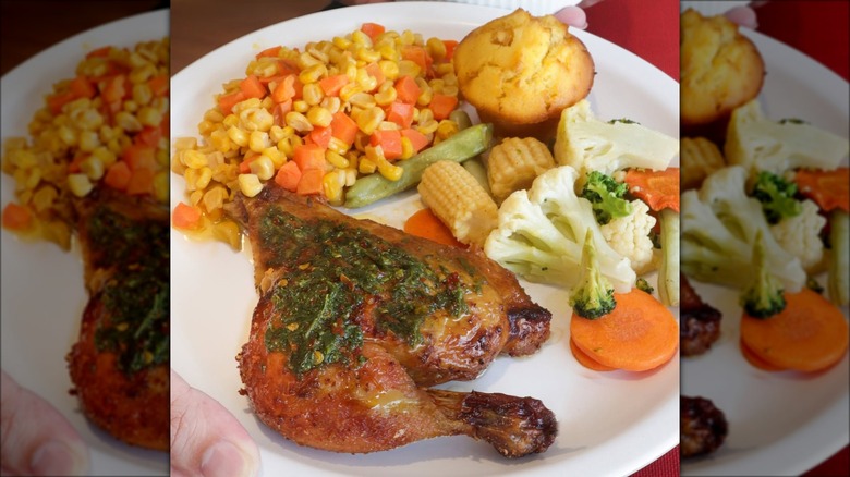 Person holding plate with chicken and sides in a Kenny Rogers Roasters restaurant in the Philippines.
