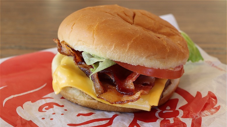 Wendy's burger with lettuce, tomato, cheese, and bacon