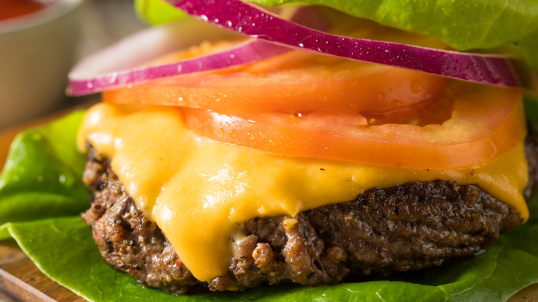 Bunless keto cheeseburger with lettuce tomato and onion