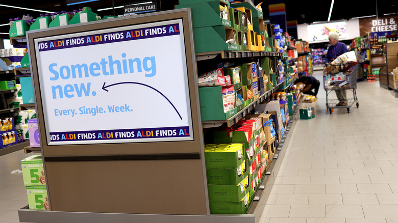 Aldi Finds sign inside an Aldi store with shoppers in the aisle