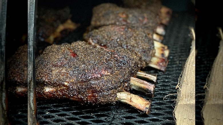 racks of spice-encrusted beef ribs cooking