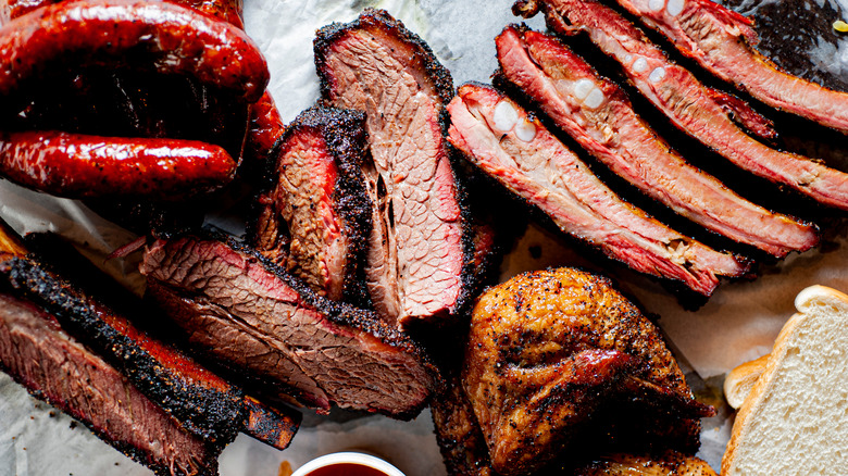 barbecue platter with brisket, ribs, sausage, chicken, bread, and sauce