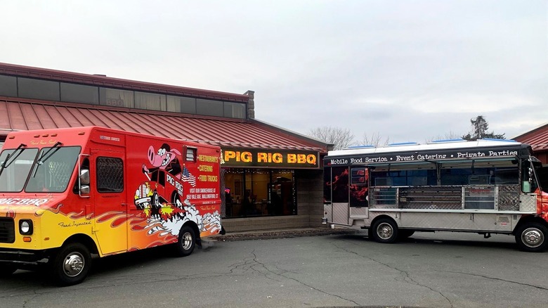 Two Pig Rig food trucks in front of the Pig Rig BBQ restaurant