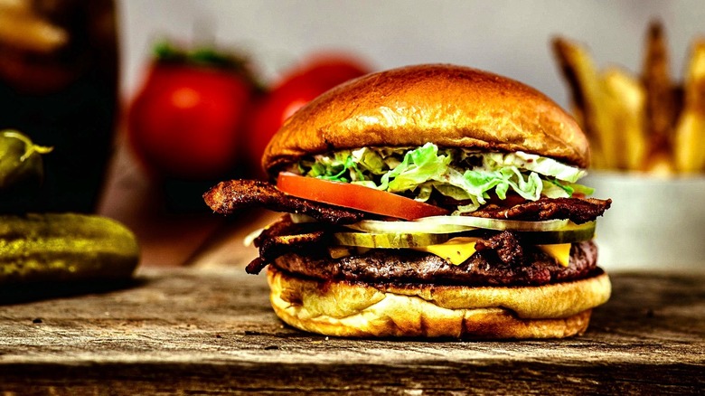 A hamburger sitting on a cutting board
