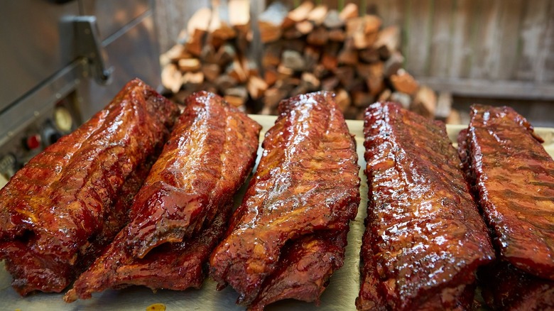 Five racks of ribs covered in sauce