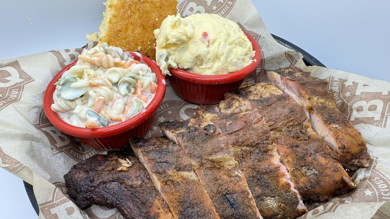 A plate with corn bread, barbecue, and sides