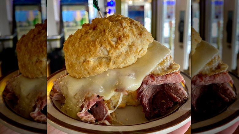 A breakfast biscuit with ham, egg, cheese, and gravy